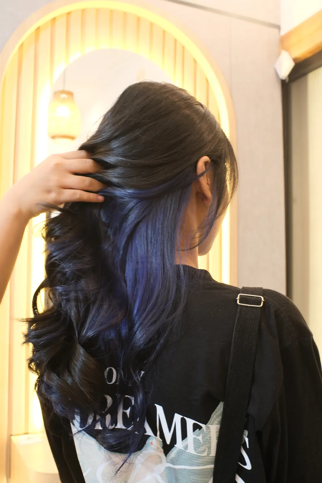 Hasil coloring biru pada lapisan dalam rambut yang diperlihatkan dari samping belakang.