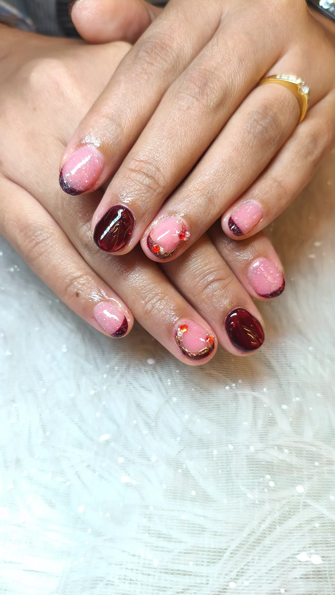 Detail hasil nail pink dan burgundy dengan aksen dekoratif.
